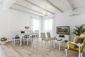 ナクソス・コラにあるVilla Nektar, Luxury Apartment in Chora Naxosの白いリビングルーム(テーブル、椅子付)