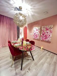 فندق دانة السكني في بريدة: غرفة طعام مع طاولة وكراسي حمراء