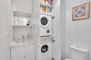 a white bathroom with a washer and dryer in it at Ren Basera in Mount Buller +3 photos