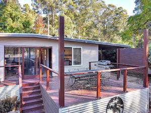 a house with a large deck with a grill at Ren Basera in Mount Buller
