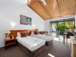 a bedroom with two beds and a desk and a window at Nautical Owl 122 Nautilus Beach Resort in Coffs Harbour +15 photos