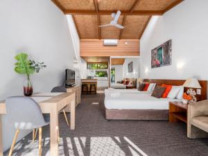 a bedroom with a bed and a dining room at Nautical Owl 122 Nautilus Beach Resort in Coffs Harbour