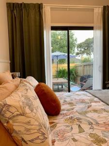 a bedroom with a bed with a flower pattern on it at Stylish Geelong Cabin - Your home away from home in Belmont