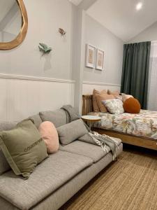 sala de estar con sofá y cama en Stylish Geelong Cabin - Your home away from home en Belmont