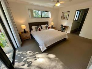 a bedroom with a bed and two lamps and a window at Sandstone Point Sleeps 10, 4-bedroom home in Sandstone Point