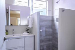 Un baño blanco con lavabo y ducha. en Dazzling house in the heart of Coyoacan/12 guests, en Ciudad de México