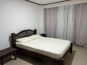 1 dormitorio con cama, mesa y ventana en 7 De Marzo Sabana, en San José