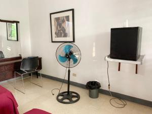 a living room with a fan and a television at African Symbol Guest House in Montego Bay