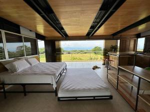 1 dormitorio con 2 camas y ventana grande en Comfortable glamping loft with pool and vineyards, en Rivera