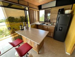 una cucina con tavolo in legno e frigorifero di Comfortable glamping loft with pool and vineyards a Rivera