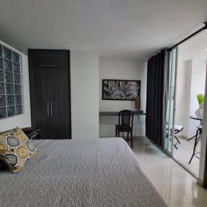 a bedroom with a bed and a desk in a room at Ardival apartment - WAIWA HOST in Bucaramanga