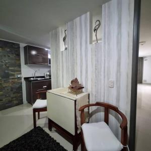 a kitchen with a table and a chair in a room at Ardival apartment - WAIWA HOST in Bucaramanga