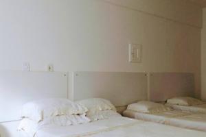 1 dormitorio con 2 camas con almohadas en APARTAMENTO COPACABANA saleta, quarto grande com ar cond wi-fi a 2 qds da praia, en Río de Janeiro