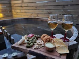 a wooden table with two glasses of wine and food at Cabañas Antü Küyen Melipeuco in Melipeuco
