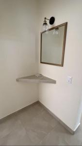a white room with a shelf and a mirror at Los Amores Apartments B in Pérula