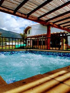 a swimming pool in front of a house at La Alhambra Hotel Boutique in Villa de Leyva