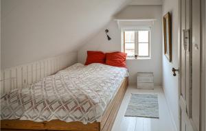 a bedroom with a bed with orange pillows and a window at Beautiful Home In Anholt With 4 Bedrooms in Anholt