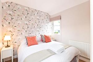 um quarto com uma cama com uma parede floral em Church View em Buxton