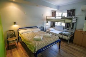 een slaapkamer met een bed en een stapelbed bij YHA Cairns Central in Cairns