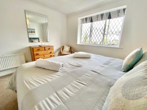 sypialnia z dużym białym łóżkiem i komodą w obiekcie Heidaway - Padstow w mieście Padstow