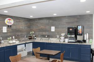 a kitchen with blue cabinets and a wooden wall at Super 8 by Wyndham Morganton in Morganton
