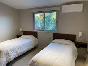 two beds in a room with a window at Duplex Renovado in San Juan
