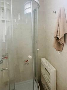 y baño con ducha y puerta de cristal. en Lovely one bedroom apartment in Vicente Lopez en Vicente López