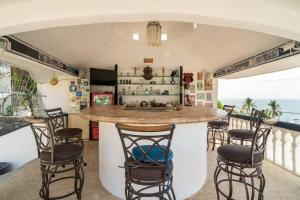 una cocina con una barra con sillas y el océano en Gran habitacion con terraza vista espectacular, piscina en Acapulco