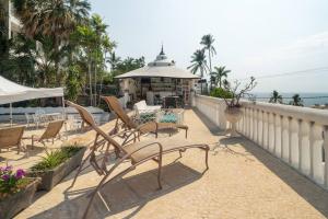 a balcony with chairs and a gazebo on the beach at Gran habitacion con terraza vista espectacular, piscina in Acapulco