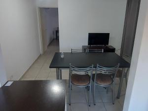 una mesa negra con 2 sillas y un ordenador portátil en Departamento Salta en Mendoza