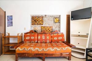 a bedroom with a bed with orange pillows at Villa Palmitas acogedor departamento nivel piscina gigante jardines in Acapulco