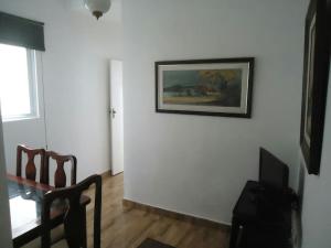 una sala de estar con una mesa y una foto en la pared en APARTAMENTO COPACABANA saleta, quarto grande com ar cond wi-fi a 2 qds da praia, en Río de Janeiro