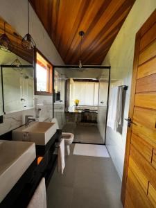 La salle de bains est pourvue d'un lavabo et d'un miroir. dans l'établissement Chalés Alto dos Pires, à São Bento do Sapucaí