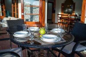 a table with plates and glasses on top of it at Enjoy Sunset @ Tropical Lookout in Kingstown
