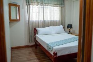 ein Schlafzimmer mit einem Bett mit einem Fenster und einem Bettbezugspeck in der Unterkunft Enjoy Sunset @ Tropical Lookout in Kingstown