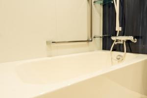 a bathroom with a bath tub with a mirror at Cinnamonhotel2 in Osaka