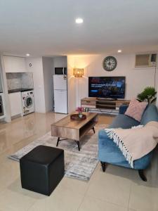 a living room with a blue couch and a table at Private & Cosy Two Storey Guest House in Guildford