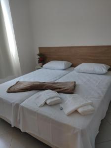 un grande letto con lenzuola bianche e cuscini bianchi di Condomínio Barretos Thermas Park a Barretos