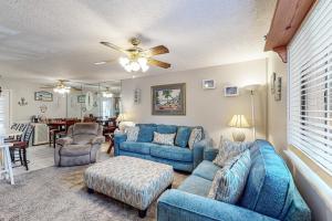 - un salon avec des canapés bleus et un ventilateur de plafond dans l'établissement Gulf Highlands: 181 Gulf Highlands Blvd., à Panama City Beach