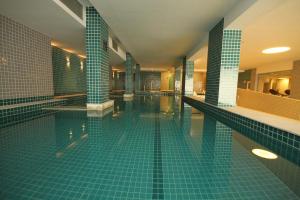 a large swimming pool with green tile walls and floors at Linda suíte de hotel, acomoda até 3 pessoas Milly in Rio de Janeiro