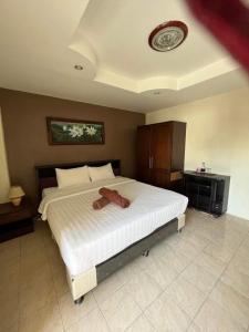 a bedroom with a large white bed with a clock on the ceiling at the links hotel in Pattaya Central