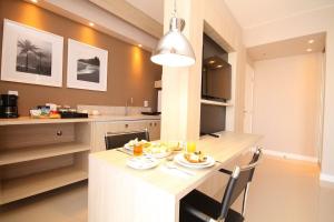 a kitchen with a table with plates of food on it at Linda suíte de hotel, acomoda até 3 pessoas Milly in Rio de Janeiro