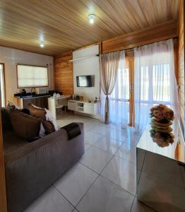 ein Wohnzimmer mit einem Sofa und einem Tisch in der Unterkunft Casa em Bombinhas Mariscal in Bombinhas