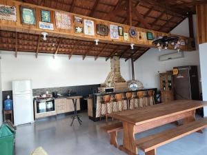 ein Esszimmer mit einem Holztisch und einer Küche in der Unterkunft Casa em Bombinhas Mariscal in Bombinhas