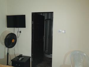 a room with a black door with a television on a wall at Joefad Home Stay - Wuse Zone 5 in Abuja