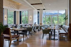 een eetkamer met tafels, stoelen en ramen bij The Westin Riverfront Resort & Spa, Avon, Vail Valley in Avon