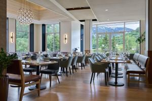 un comedor con mesas, sillas y ventanas en The Westin Riverfront Resort & Spa, Avon, Vail Valley, en Avon