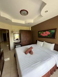 a bedroom with a large bed with a large white bedspread at the links hotel in Pattaya Central