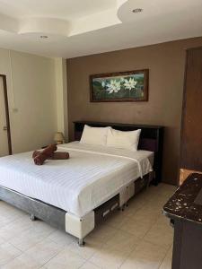 een groot bed met een teddybeer erop bij the links hotel in Pattaya +4 foto's