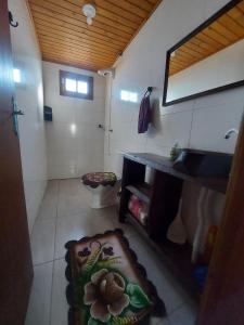 ein Bad mit einem Waschbecken und einem WC in einem Zimmer in der Unterkunft Chalé Rancho Coração Cigano in Araranguá